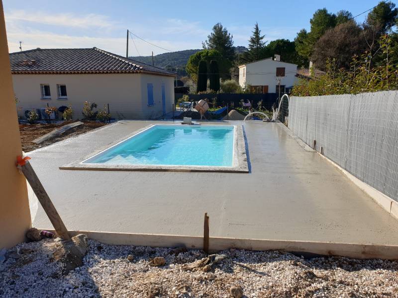 Réalisation d'une terrasse en béton autour d'une piscine coque polyester modèle 